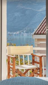 Biały fotel na balkonie z widokiem na wodę w obiekcie Apartmani Vico w mieście Herceg Novi