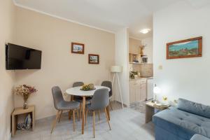 sala de estar con mesa, sillas y sofá en Apartmani Vico, en Herceg-Novi