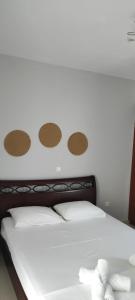 białe łóżko z brązowymi kropkami na ścianie w obiekcie Small Patak House w mieście Psalidi