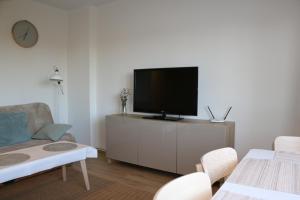 un salon avec une télévision à écran plat sur une armoire dans l'établissement Apartament Freedom, à Kołobrzeg