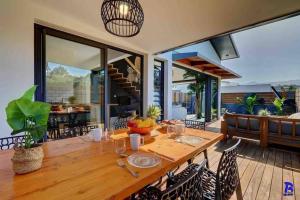 an outdoor dining room with a wooden table and chairs at Le ti coin l'ombraz in Saint-Pierre
