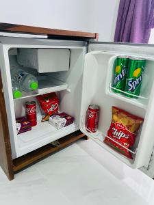 an open refrigerator with drinks and snacks in it at Heaven Breeze in Kandy