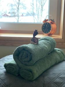 a pile of towels on a bed next to a clock at Appartement in Jämtland bij Gusto Stables ... in Föllinge