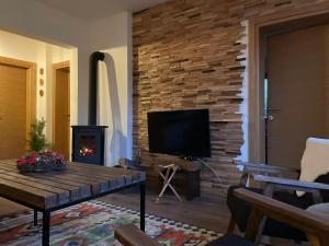 a living room with a fireplace and a television at Vikendica Paša in Pale