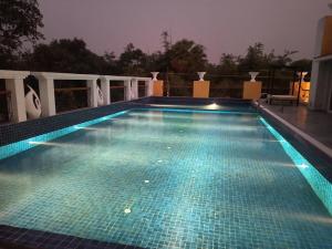 una piscina notturna con luci blu di ARANYA RESORT BOLPUR a Bolpur