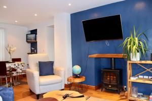 una sala de estar con una pared azul en Extended Fishermans cottage with stunning sea views, en Mumbles