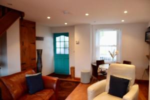 a living room with a couch and a green door at Extended Fishermans cottage with stunning sea views in The Mumbles
