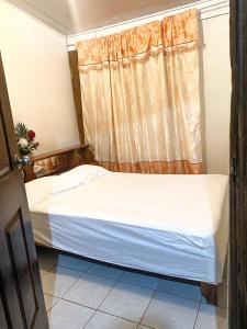 ein kleines Bett in einem Zimmer mit Fenster in der Unterkunft Apartamento in Aguas Zarcas