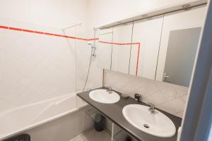 La salle de bains est pourvue de 2 lavabos et d'un miroir. dans l'établissement Le Neptune Apt 85m2 3ch Appart Hotel Poitiers, à Poitiers