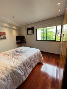 1 dormitorio con cama y ventana grande en APART HOTEL LUXO IPANEMA, en Río de Janeiro