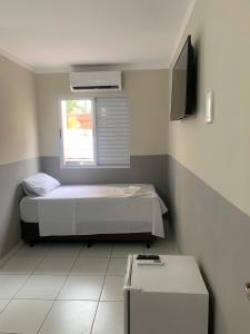 a small bedroom with a bed and a window at Hotel Barão Ribeirão in Ribeirão Preto