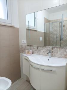 a bathroom with a white sink and a mirror at Sweet Home Annalisa in Ortona