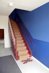 Una escalera en una habitación con una pared azul en Roter Hirsch, en Oderberg