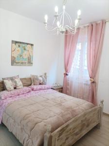 a bedroom with a bed with pink curtains and a chandelier at Sweet Home Annalisa in Ortona