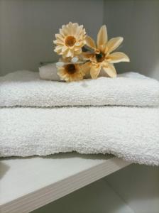 a pile of towels with flowers on top of them at Sweet Home Annalisa in Ortona