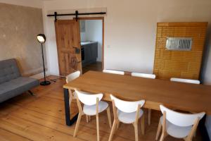 ein Esszimmer mit einem Holztisch und weißen Stühlen in der Unterkunft Roter Hirsch in Oderberg