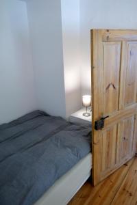1 dormitorio con 1 cama y puerta de madera en Roter Hirsch, en Oderberg