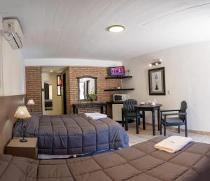 ein Schlafzimmer mit einem Bett und einem Tisch mit Stühlen in der Unterkunft Hotel La Colina del Sol in Villa Carlos Paz