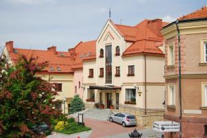 un edificio con un coche aparcado delante de él en Hotel Basztowy, en Sandomierz