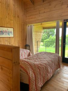 um quarto com uma cama e uma janela em Cabaña Eco Loft Chiloe Chonchi em Chonchi