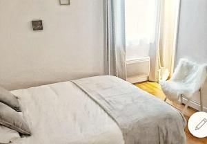um quarto com uma cama, uma cadeira e uma janela em L'escale Cocooning Appartement T2 Centre 3 Étoiles em Bagnères-de-Bigorre