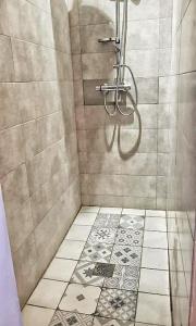 ein Bad mit einer Dusche und Fliesenboden in der Unterkunft L'escale Cocooning Appartement T2 Centre 3 Étoiles in Bagnères-de-Bigorre