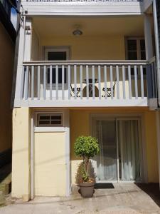 ein Haus mit einem Balkon, einer Tür und einer Pflanze in der Unterkunft L'escale Cocooning Appartement T2 Centre 3 Étoiles in Bagnères-de-Bigorre