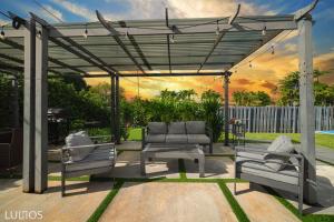 a pergola with two couches and a table at Magical Miami Retreat with Heated Pool, Mini Golf, and Basketball Court L19 in Miami