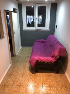 Un dormitorio con una cama con una manta morada. en Casa FRENCH. en Mar del Plata