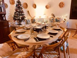 una mesa con platos y vasos y un árbol de Navidad en Villa sul Mare Calalunga Calasetta Sant Antioco, en Calasetta