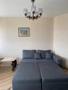 - un grand lit bleu dans une chambre avec une table dans l'établissement ApartPoltava НОВИЙ будинок, в самому ЦЕНТРІ 2-ОКРЕМІ кімнати, ПАНОРАМНИЙ БАЛКОН, à Poltava