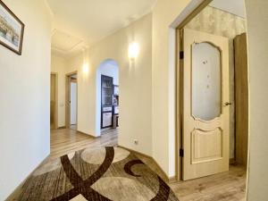un couloir avec une porte blanche et un tapis dans l'établissement ApartPoltava НОВИЙ будинок, в самому ЦЕНТРІ 2-ОКРЕМІ кімнати, ПАНОРАМНИЙ БАЛКОН, à Poltava