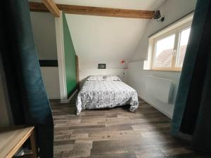 1 dormitorio con 1 cama en una habitación con ventana en Petite maison de charme, en Dinsheim