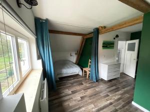 1 dormitorio con 1 cama con cortinas azules en Petite maison de charme, en Dinsheim