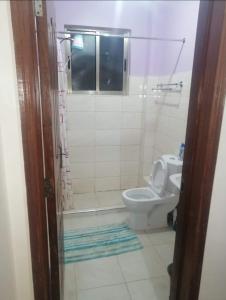 a bathroom with a toilet and a shower and a sink at 3Bedroom Greatwall Gardens Mombasa Rd NBO in Makandara
