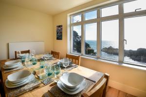 a dining room with a table with a view of the ocean at Fishermans Heights in Polperro