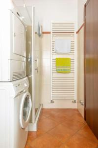 a bathroom with a washing machine and a washer at La casetta nel borgo in Pescantina