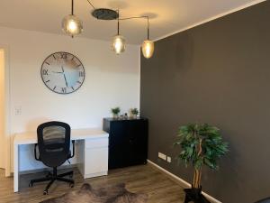an office with a desk and a clock on the wall at Mitten in Kempten - Großzügig - Tolles Design in Kempten