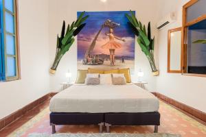 a bedroom with a bed with a painting on the wall at AmazINN Places Casco Viejo Pool and Rooftop V in Panama City