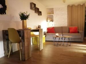 a living room with a couch and a table and chairs at appartement cosy situé à 2mn de la plage à pied climatise in Villefranche-sur-Mer