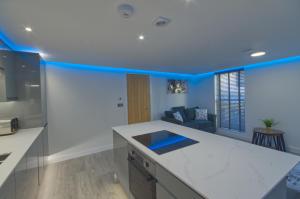 a kitchen with blue walls and a counter top at Marina Walk, New Luxury Coastal Apartment in The English Riviera, close to the Shops, Bars and Restaurants with Torquay Marina and Torre Abbey Sands Beach a short walk away! in Torquay