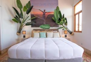 - une chambre avec un grand lit blanc et 2 plantes dans l'établissement AmazINN Places Casco Viejo Pool and Rooftop XIII, à Panama City 18 autres photos