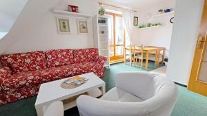 ein Wohnzimmer mit einem roten Sofa und einem Stuhl in der Unterkunft Apartmán 6 u sjezdovek in Rokytnice nad Jizerou