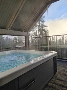 a large hot tub in a house with a large window at Huvila Hukanhuippu in Syöte