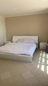 Una cama con sábanas blancas y almohadas en un dormitorio en Bana Bana Resort, en Durat Alarous