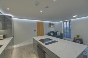 a kitchen with a counter top and a living room at Marina Walk, New Luxury Coastal Apartment in The English Riviera, close to the Shops, Bars and Restaurants with Torquay Marina and Torre Abbey Sands Beach a short walk away! in Torquay