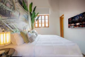 een groot wit bed in een kamer met een raam bij AmazINN Places Casco Viejo Pool and Rooftop XI in Panama-Stad