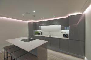 a kitchen with black and white cabinets and a counter at Marina Walk, New Luxury Coastal Apartment in The English Riviera, close to the Shops, Bars and Restaurants with Torquay Marina and Torre Abbey Sands Beach a short walk away! in Torquay