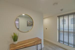 a mirror on a wall next to a window at Marina Walk, New Luxury Coastal Apartment in The English Riviera, close to the Shops, Bars and Restaurants with Torquay Marina and Torre Abbey Sands Beach a short walk away! in Torquay +6 photos