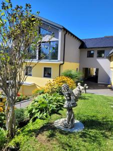 a statue in a garden in front of a building at Lucashof Millstättersee in Millstatt